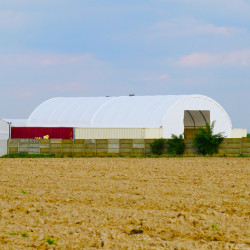 Zadaszenia konteneroweZadaszenie kontenerowe C4080 12×24 m to konstrukcja, która cechuje się solidnością i stabilnością, dzięki zastosowaniu grubej rury z ocynkowanej stali. To rozwiązanie zapewnia nie tylko odporność na korozję, ale również wytrzymałość na różnorodne warunki atmosferyczne. Rama wykonana z wysokogatunkowej stali o średnicy 76x1,80  mm oraz płatwie 60 mm, każde z grubością ścianki 1,5 mm, gwarantują konstrukcji doskonałą stabilność. Dodatkową zaletą jest zastosowanie wysokiej jakości plandeki o grubości  900 g, co podkreśla wytrzymałość konstrukcji i zapewnia maksymalną ochronę przechowywanych towarów.
Zadaszenie kontenerowe C4080 12×24 m wytrzymuje obciążenie śniegiem do 0,28 kPa oraz prędkość wiatru do 80 km/h. Materiały użyte do produkcji zadaszenia nad kontener są odporne na uszkodzenia mechaniczne oraz różnorodne obciążenia, co gwarantuje długowieczność i niezawodność rozwiązania. Co więcej, użytkowanie tej konstrukcji nie wymaga uzyskania pozwolenia na budowę, co znacząco skraca czas oraz formalności związane z instalacją. Dostawa towaru „od ręki” na terenie Polski w 2-3 dni, w Unii Europejskiej w 3-5 dni, a montaż zajmuje 2-5 dni.